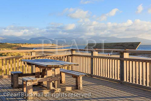 New wooden decking and picnic tables above the 
beach with view to mountains. Newborough, Isle of 
Anglesey, North Wales, UK, Britain