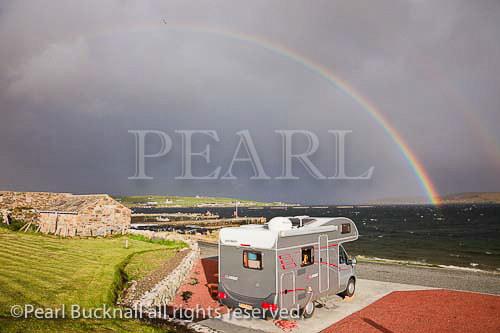 Gardiesfauld youth hostel campsite with rainbow and 
grey clouds over the sea. Uyeasound, Unst, Shetland 
Islands, Scotland, UK

Keywords: camping coast weather