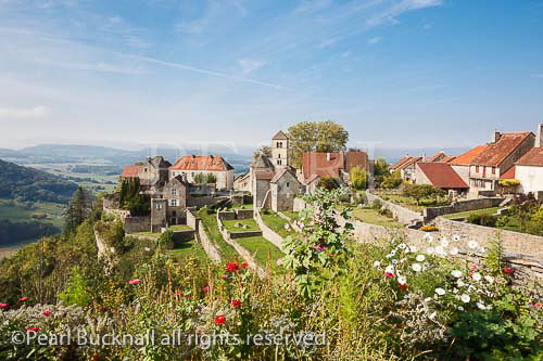 Picturesque hilltop village with garden flowers in 
foreground in Chateau Chalon, Jura, Franche-Comte, 
France, Europe. One of Les Plus Beaux Villages de 
France.