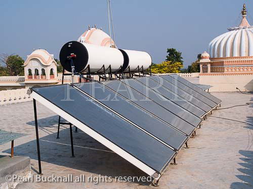 Solar Panels in side view on roof for heating water 
supply of new hotel in 16th century city. Orchha 
Madhya Pradesh India Asia