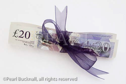 Sterling �20 pound note tied up on white background. 
Studio still life UK. 