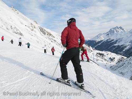 Male skier on snow covered ski slopes in the Austrian 
Alps. St Anton am Arleberg, Tyrol, Austria, Europe. 