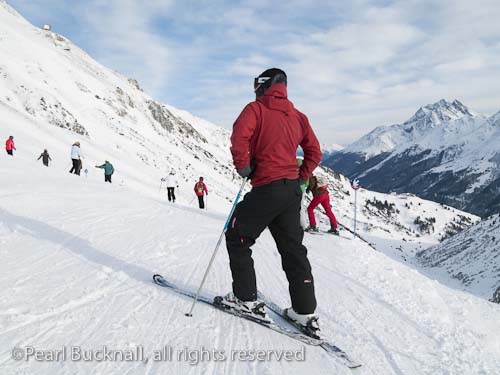 Male skier on snow covered ski slopes in the Austrian 
Alps. St Anton am Arleberg, Tyrol, Austria, Europe. 