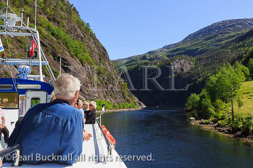 Tourists on a sightseeing cruise boat along narrow 
Mostraumen fjord from Bergen, Hordaland, Norway, 
Scandinavia, Europe