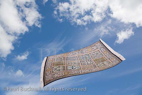 Magic carpet flying across blue sky with white clouds.

Keywords: digital comp composit