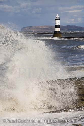 Penmon Point, Isle of Anglesey, North Wales, UK. 
Rough sea and windy weather Penmon lighthouse on 
rocky coast

Keywords: coastline, waves, big waves,