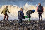 Children enjoy dodging waves at Penmon beach on 
Isle of Anglesey, North Wales, UK, Britain