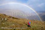 Hiker hiking in wet weather with a rainbow on Pen yr 
Helgi Du in the Carneddau mountains of Snowdonia 
National Park, North Wales, UK, Britain