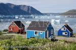 Typical colourful Greenlandic houses overlooking 
Tunulliarfik fjord with icebergs floating in summer. 
Narsaq, Kujalleq, South Greenland