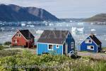 Typical colourful Greenlandic houses overlooking 
Tunulliarfik fjord with icebergs floating in summer. 
Narsaq, Kujalleq, South Greenland