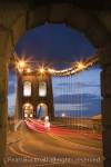 Bangor Gwynedd North Wales UK. View along the A5 
road across the Menai suspension bridge in at night. 

Keywords: Britain old building architecture historic 
landmark route Thomas Telford 