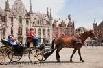 Horse and carriage tourists sightseeing tour in the 
historic square of Markt, Bruges, Belgium, Europe. 