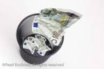 Five Euro notes being thrown into a black metal mesh 
waste paper bin

Keywords: digital compilation eurozone wasting 
money concept wastebasket throwing away