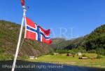 Norwegian flag flying on a boat cruise sailing from 
Mofjorden into Romarheimsfjorden and Osterfjorden 
at Mostraum, Nordhordland, Hordaland, Norway, 
Scandinavia, Europe