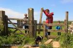 People walking on Dorset coast path with a Springer 
Spaniel passing through a dog-friendly stile near 
Worth Matravers, Dorset, England, UK, Britain. 
MR 12/09, MR 12/10, MR 12/11, PR 12/04