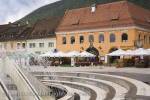 Brasov Transylvania Romania Europe / Fountain in 
pedestrianised Council Square Piata Sfatului with 
pavement cafes in medieval city centre
