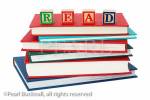 Stack of generic hardback books with the word 
READ spelt with letter blocks on top to illustrate a 
reading concept. England UK Europe