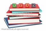 Stack of generic hardback books with the word 
READ spelt with letter blocks on top to illustrate a 
reading concept. England UK Europe