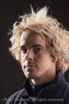 Head and shoulders portrait of a young man with big 
hair posing with a serious expression

Keywords: studio people
