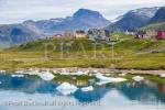 Typical traditional painted wooden houses from across 
an inlet with small icebergs. Qajaq Harbour, Narsaq, 
Kujalleq, South Greenland