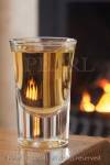 Dram of whiskey in a glass on a table by an open coal 
fire

Keywords: still life alcohol homely fireplace warm 
room 