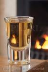 Dram of whiskey in a glass on a table by an open coal 
fire

Keywords: still life alcohol homely fireplace warm 
room 