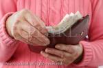 A senior woman pensioner taking ten pound notes 
out of a money wallet to pay for something. 
England, UK, Britain, Europe. MR 14/30