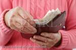 A senior woman pensioner taking ten pound notes 
out of a money wallet to pay for something. 
England, UK, Britain, Europe. MR 14/30