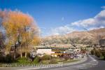 View along main street of lakeside resort town in 
autumn with southern mountains beyond. Wanaka 
Otago South Island New Zealand