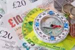 Compass on sterling money notes to illustrate the 
direction of the British economy concept. England, 
UK, Britain, Europe