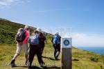 Hikers hiking on Wales Coast Path by coastal 
footpath sign on Lleyn Peninsula / Pen Llyn, 
Gwynedd, North Wales, UK, Britain, Europe