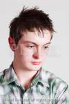 Head and shoulders portrait of a teenage boy looking 
sad