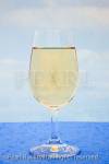 Glass of white wine with a blue sky background. Studio 
still life. 