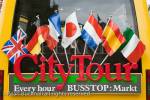City tour bus with international flags in Markt, Bruges, 
Belgium, Europe. 