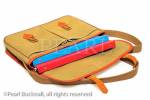 Traditional khaki canvas and leather briefcase 
containing folders isolated on a white background.