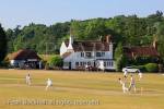 Local team playing a cricket match on the village green 
in front of the Barley Mow pub on a  summer