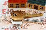 House door keys on money sterling ten pound notes 
with model houses to illustrate UK property prices 
concept. England, UK, Britain, Europe