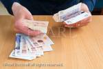 A senior person counts money in ten and twenty 
pound notes to pay for something over a counter. 
England, UK, Britain, Europe. MR 15/13