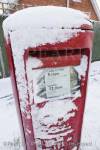 Red postbox covered in snow. Britain, UK, Europe. 

Keywords: royal mail post box mailbox winter