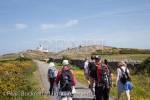 Group of walkers walking on a country lane to Point 
Lynas lighthouse. Llaneilian, Isle of Anglesey, North 
Wales, UK, Europe.

Keywords: welsh walking coast walks people activities 
Britain British