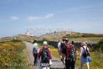Group of walkers walking on a country lane to Point 
Lynas lighthouse. Llaneilian, Isle of Anglesey, North 
Wales, UK, Europe.

Keywords: welsh walking coast walks people activities 
Britain British
