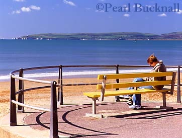 GIRL READING on a PROMENADE BENCH by the sea. 
Bournemouth, Dorset, England, UK




